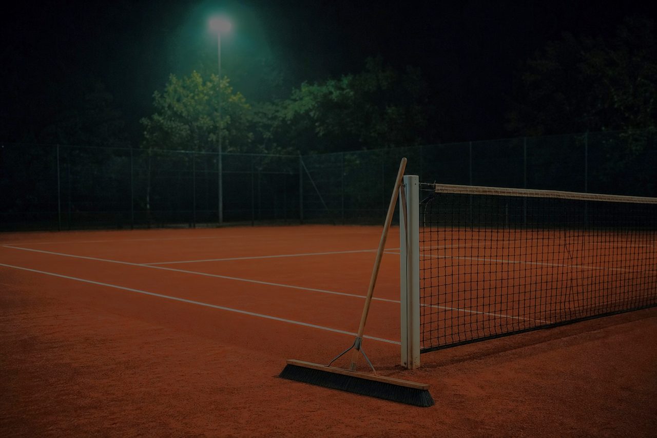 Roter Sandplatz bei Nacht mit frisch gezogenen Linien und Abziehnetz